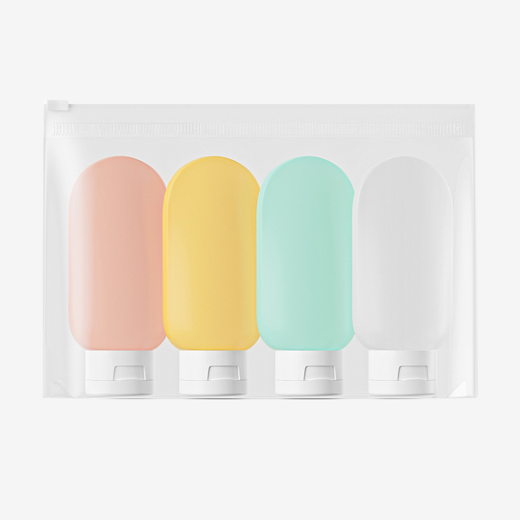 Quatre flacons de voyage en silicone rose, jaune, vert d'eau et blanc, dans une pochette zippée transparente
