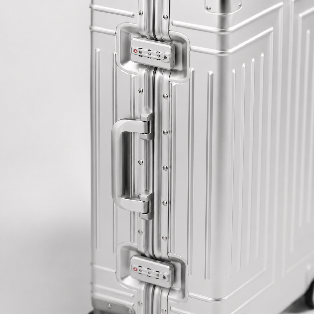 Détail du cadre de la valise Orvessa Turenne argent : deux serrures TSA à 3 chiffres encadrant la poignée latérale