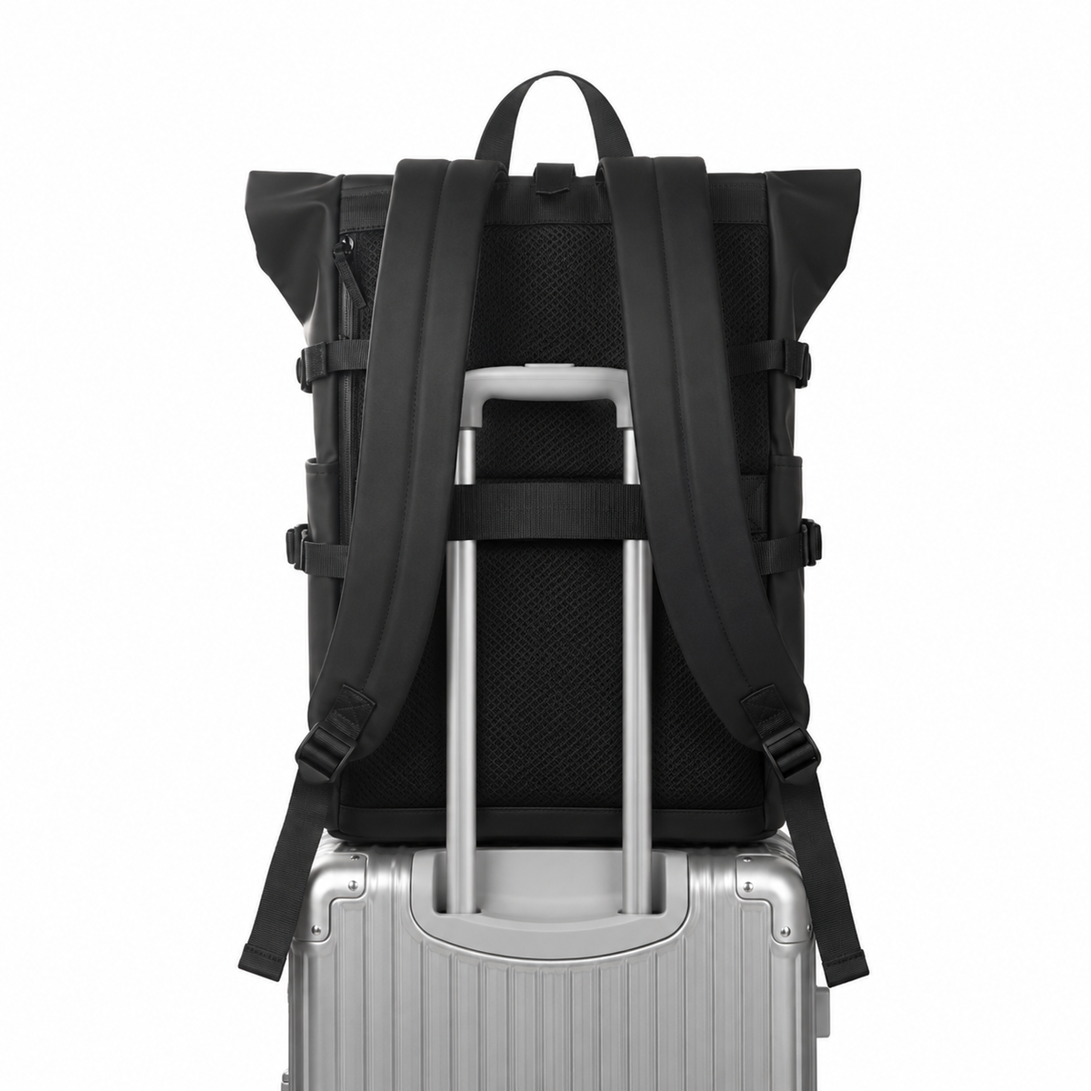 Sac à dos roll-top noir vu de dos, enfilé sur la poignée télescopique d'une valise argentée