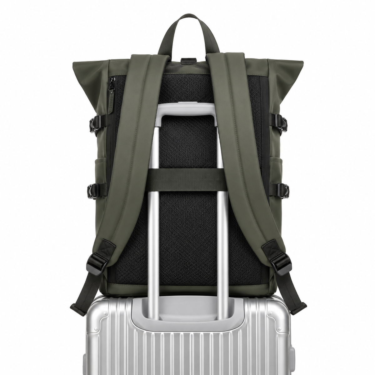Sac à dos roll-top vert olive vu de dos, enfilé sur la poignée télescopique d'une valise argentée